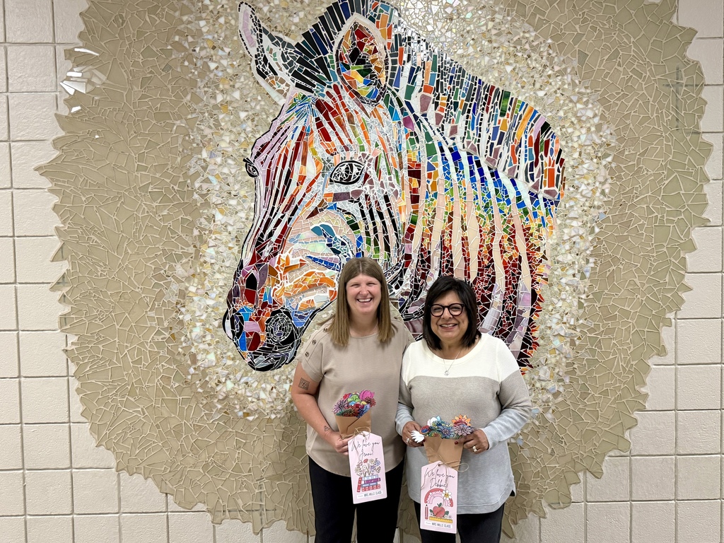 ms jenni and mrs goodwin smiling with flowers