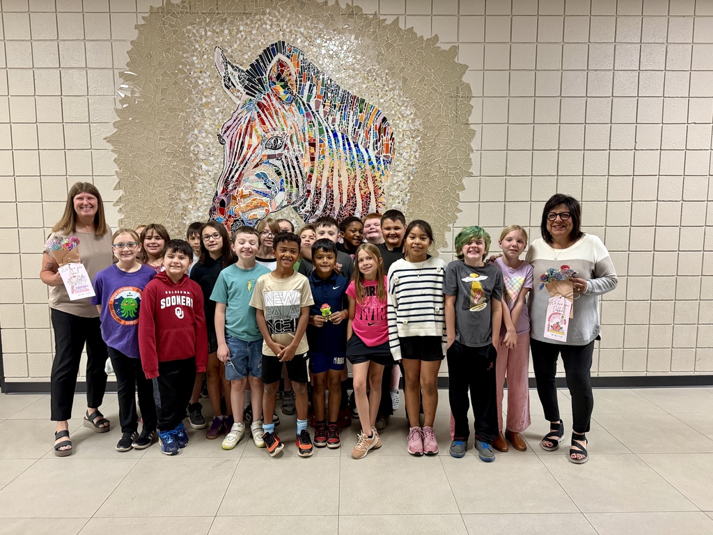 students smiling with ms jenni and mrs goodwin with the flowers they  colored