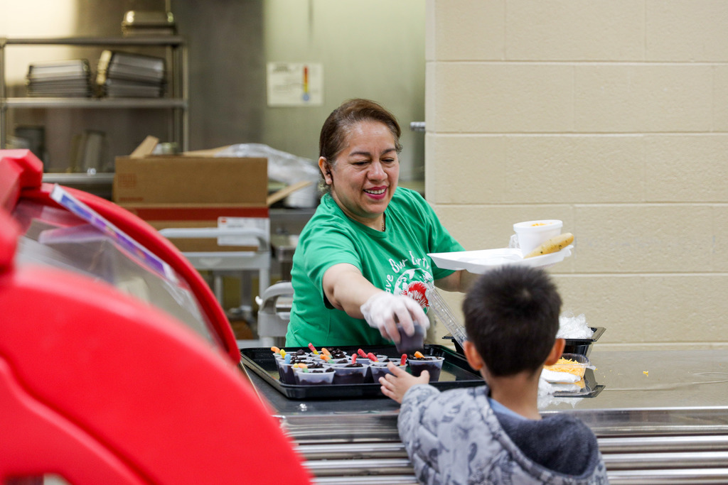 Nutrition staff handing out gummy worms and chocolate at lunch.