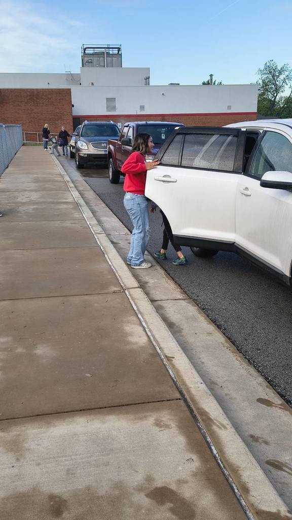 NHS member holding the door open for student