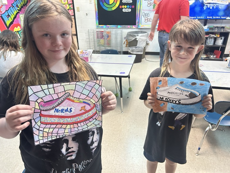 students holding their art 