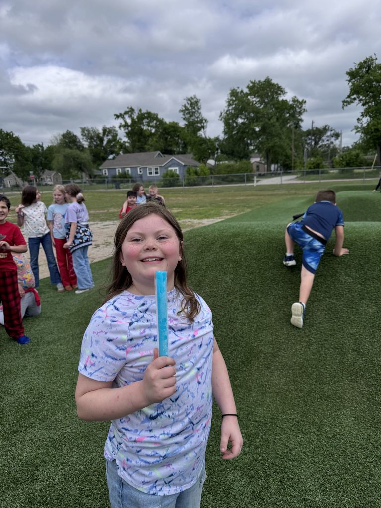 student holding popsicle, smiling