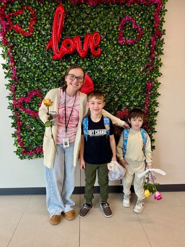 Nurse Kyla smiling with two students