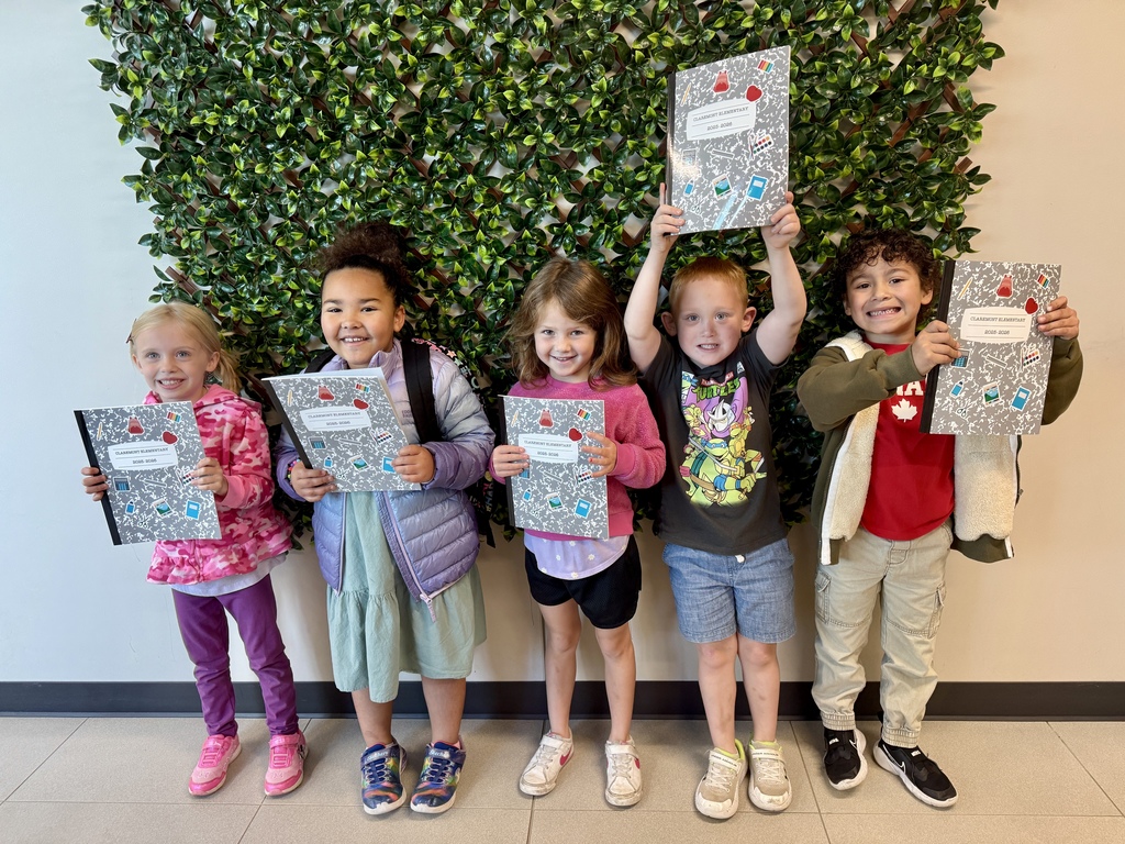 students holding yearbooks, smiling
