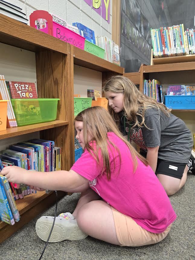Brynn and student looking at books