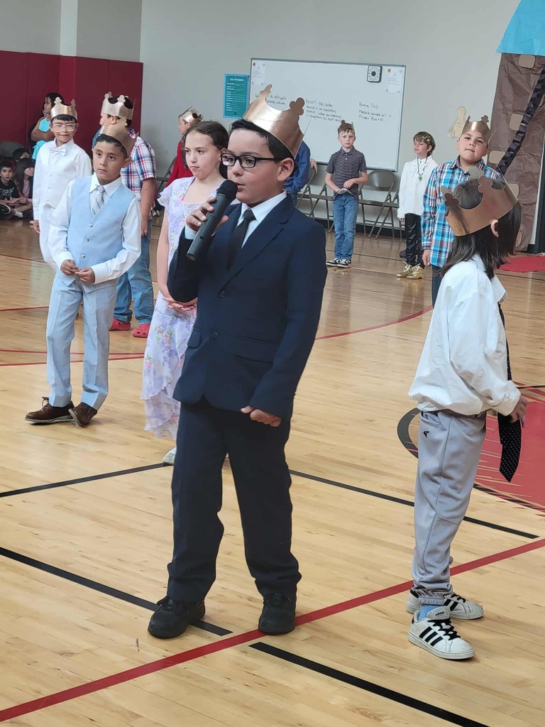 student dressed as a king speaking into a microphone