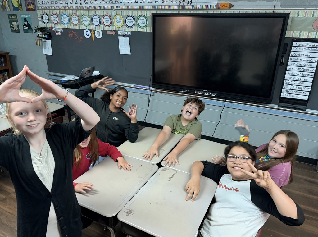students smiling with thier hands up