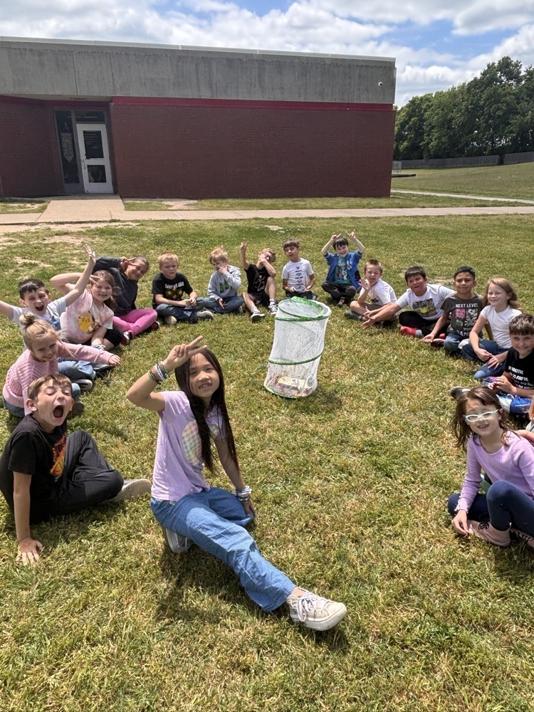 Elementary students releasing butterflies into nature.