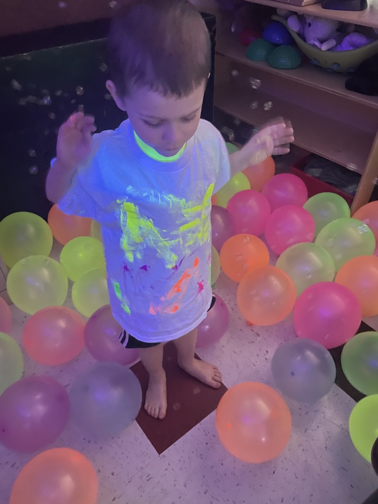 student playing in glowing balloons