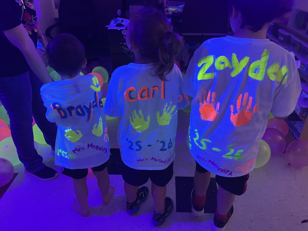students showing back with names and hand print glowing