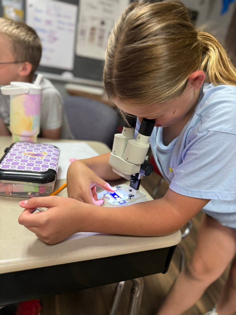 student using a microscope