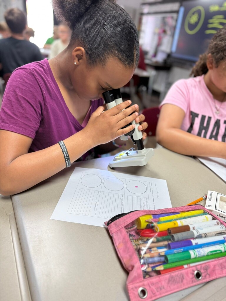 student using a microscope