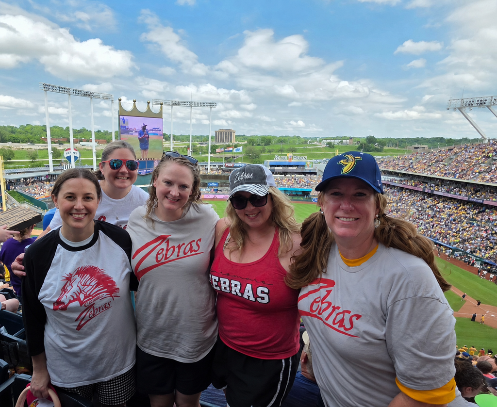 5 ladies in their zebra logo shirts at the KC baseball stadium. 