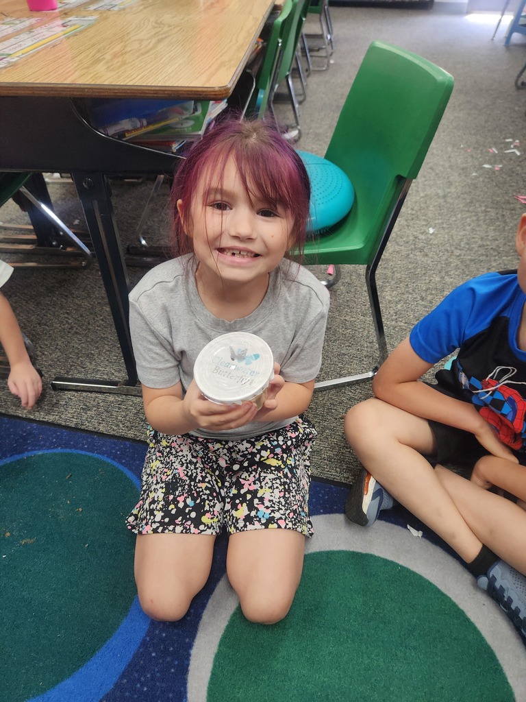 students holding catapillars and looking into cups