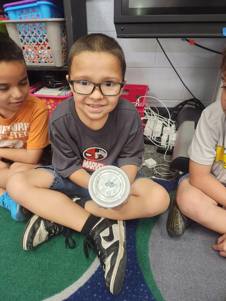 students holding catapillars and looking into cups