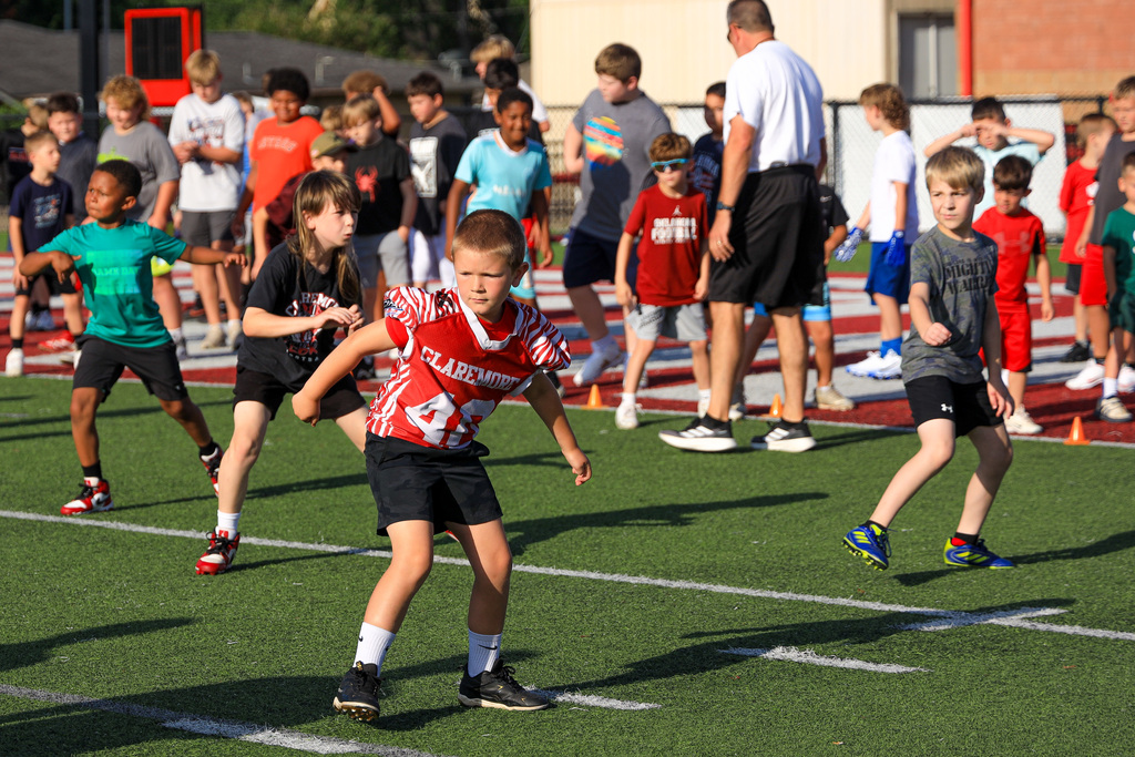 Football Camp attendees running drills.