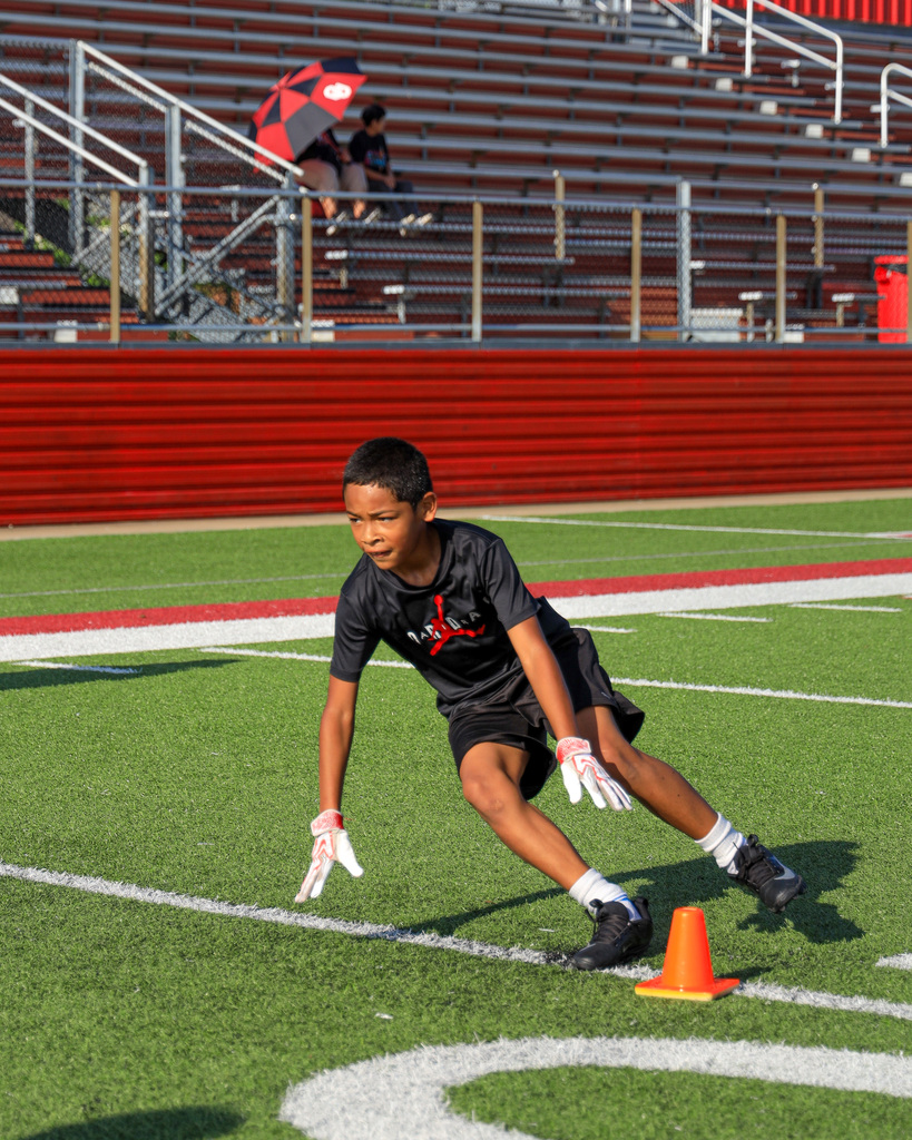 Football Camp attendees running drills.