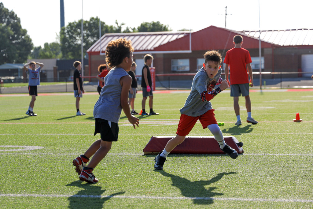 Football Camp attendees running drills.