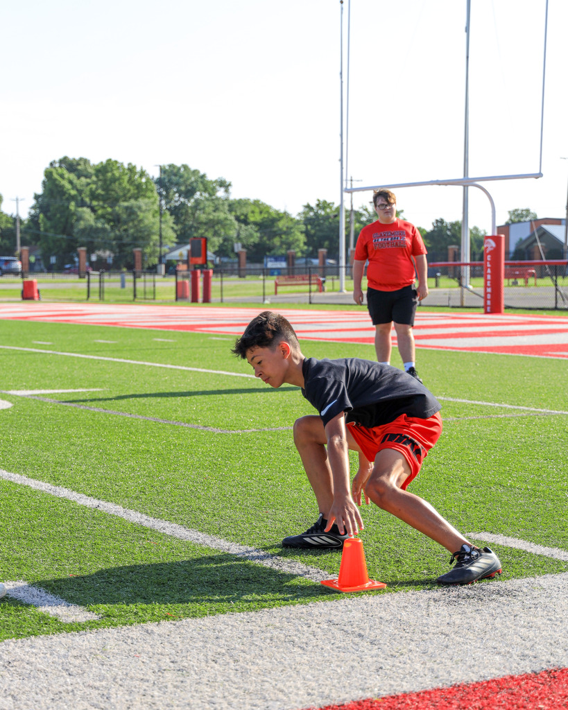 Football Camp attendees running drills.