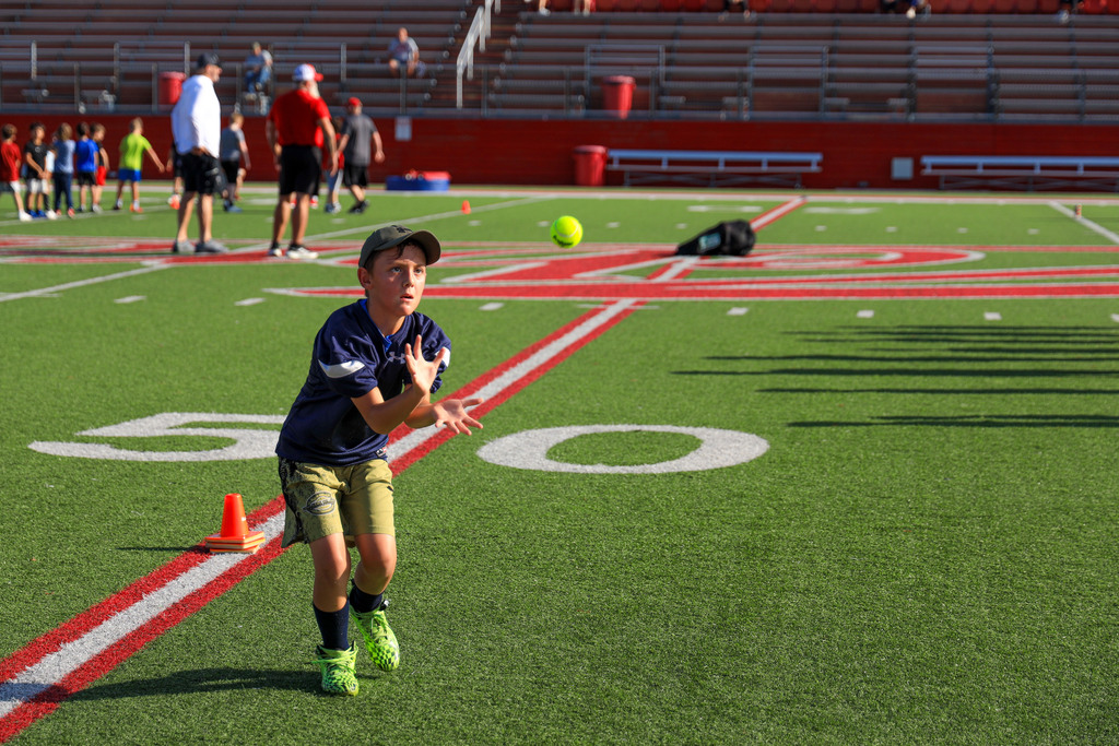 Football Camp attendees running drills.