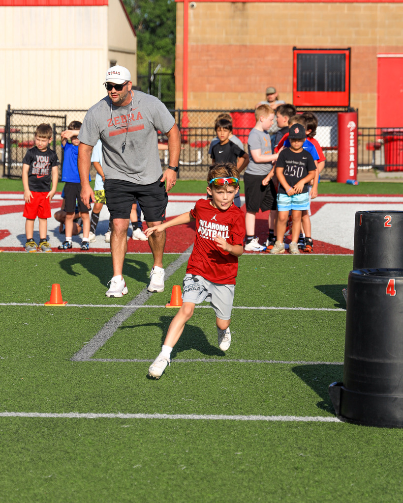 Football Camp attendees running drills.