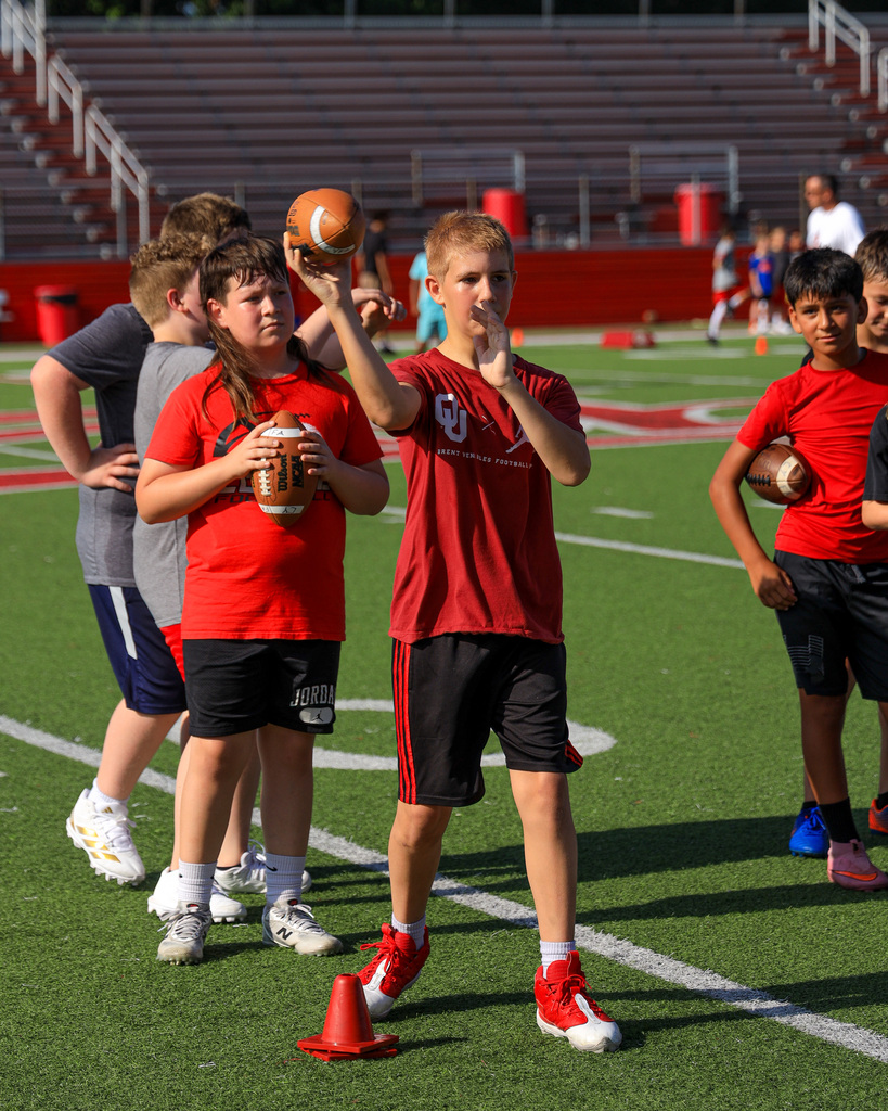Football Camp attendees running drills.