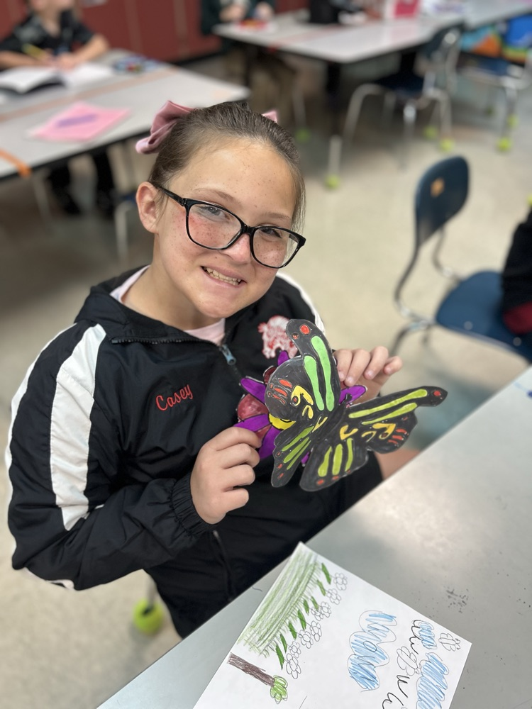 Student holding her butterfly creation