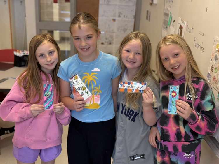 Girls smiling while holding their bookmarks