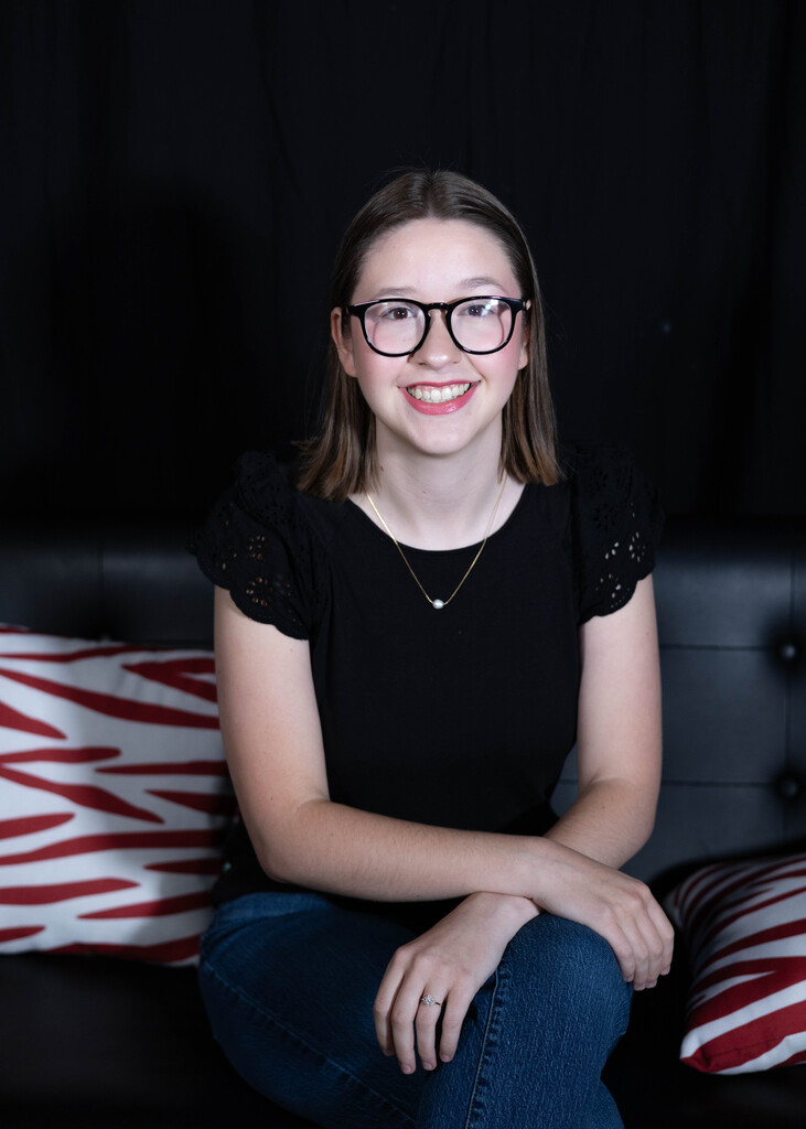 teacher sitting on a couch smiling