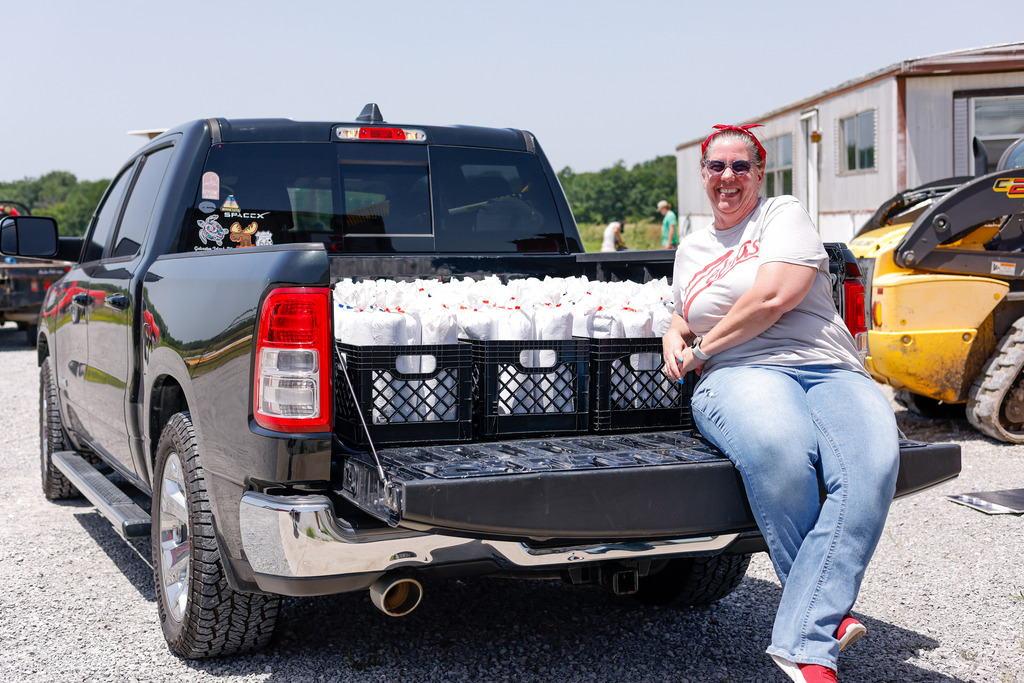 Janna posing with crates of ground beef in the back of her truck.
