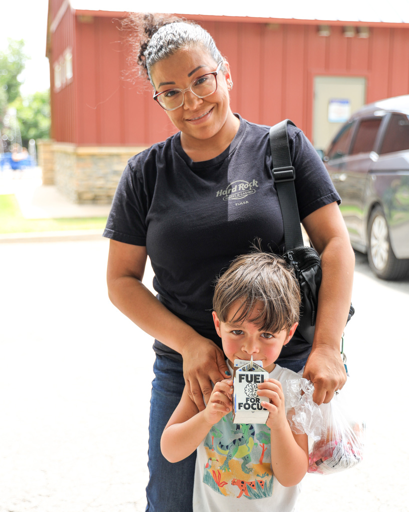 Parent with kid at splash pad.