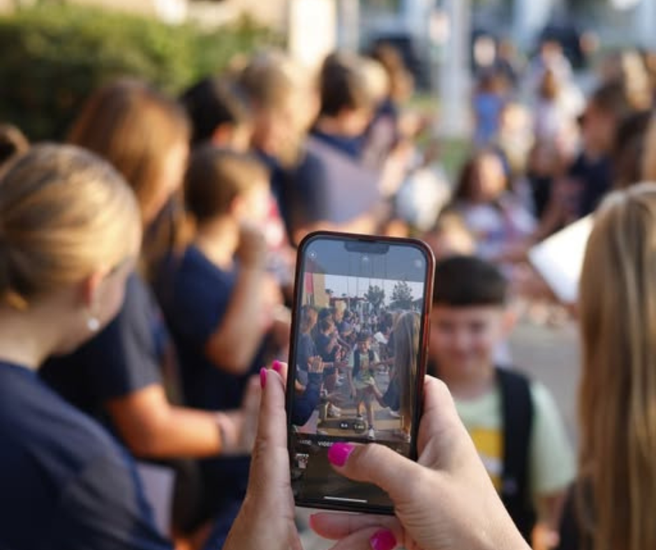 photos of a person taking a photo on their iphone of kids walking into school