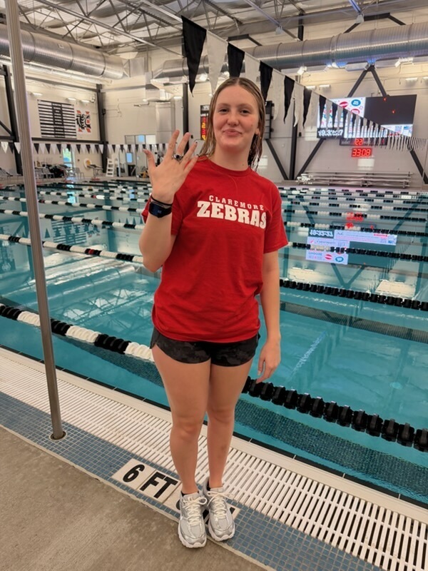 Claremore swimmer showing her All-State ring at the pool