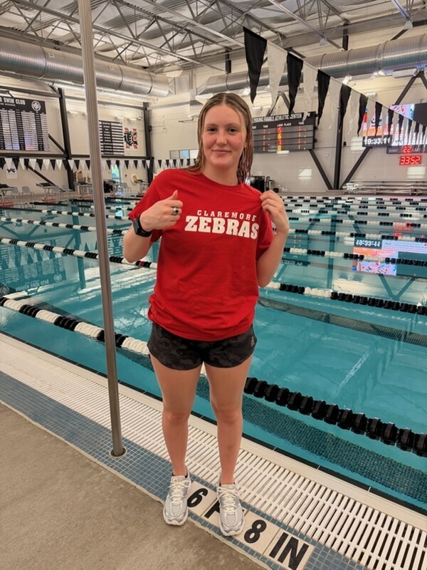 Claremore swimmer showing her All-State ring at the pool