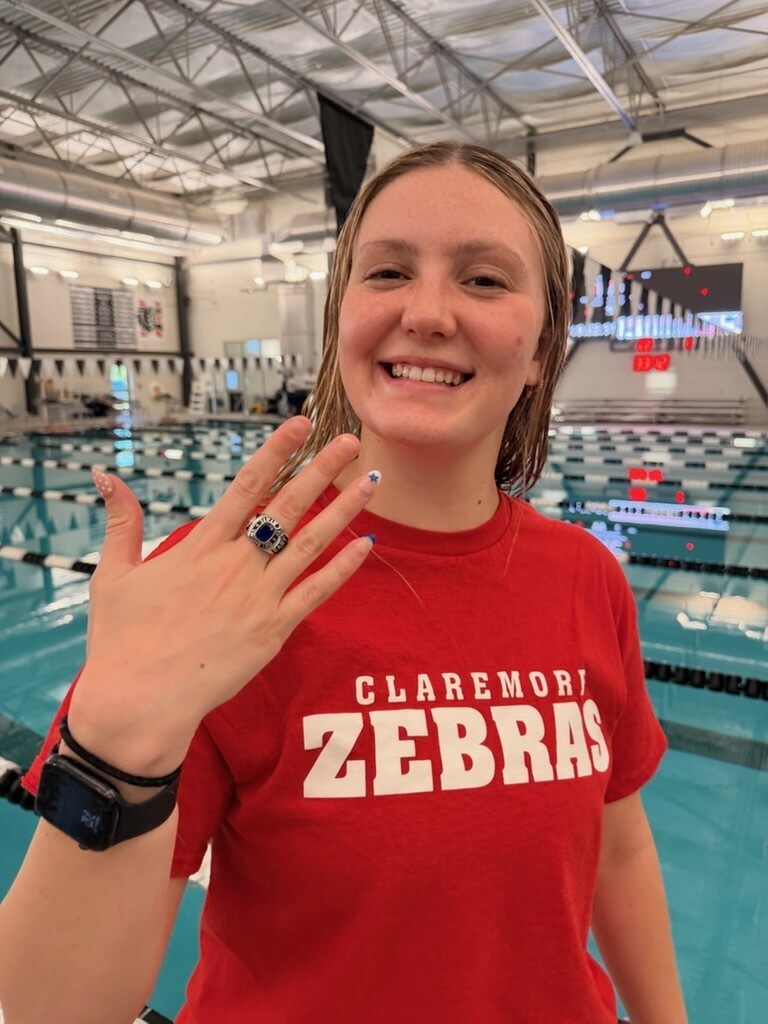 Claremore swimmer showing her All-State ring at the pool