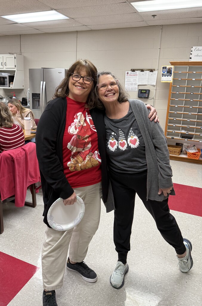 two staff members smiling and hugging