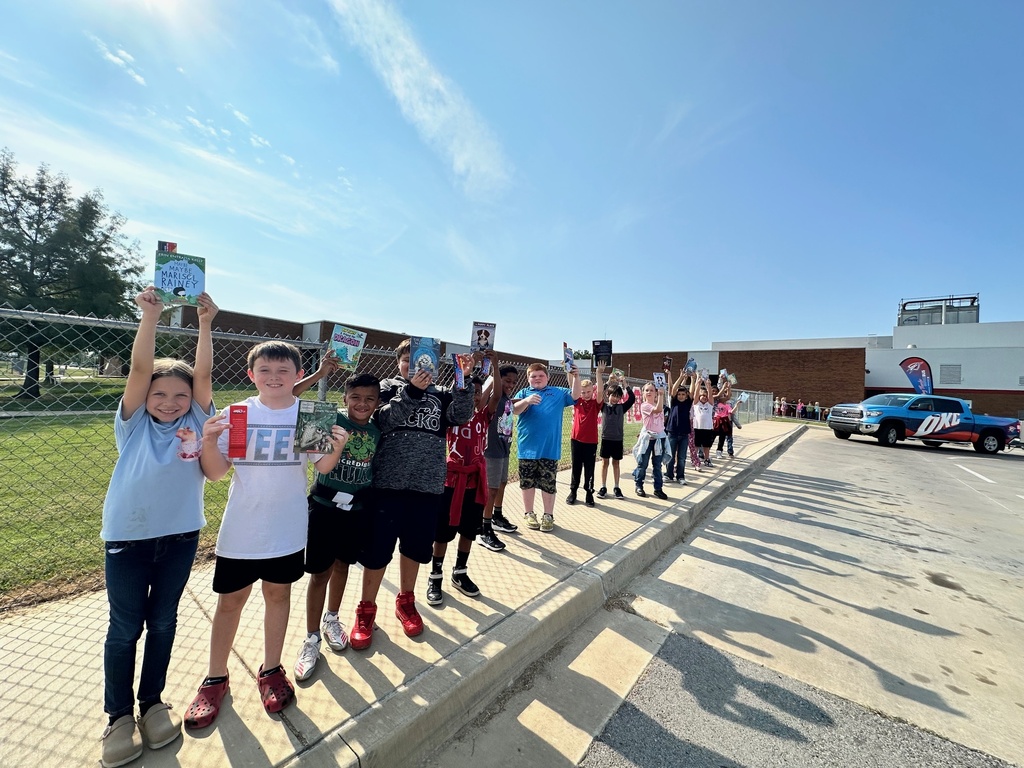 students holding books and smilign in a line