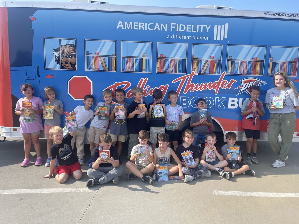 students smiling in front of the rolling thunder bus