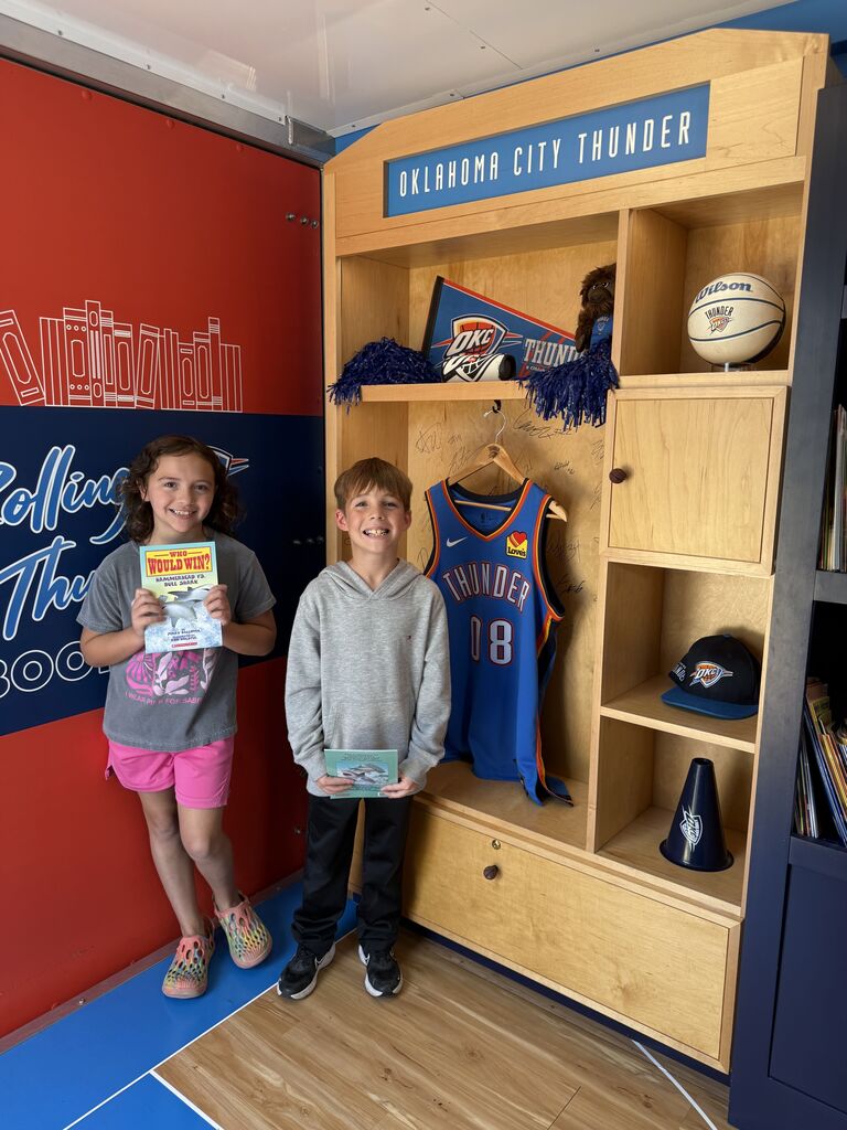 students in front of jersey holding book smiling