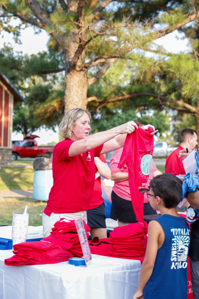 Teacher handing out shirts to students