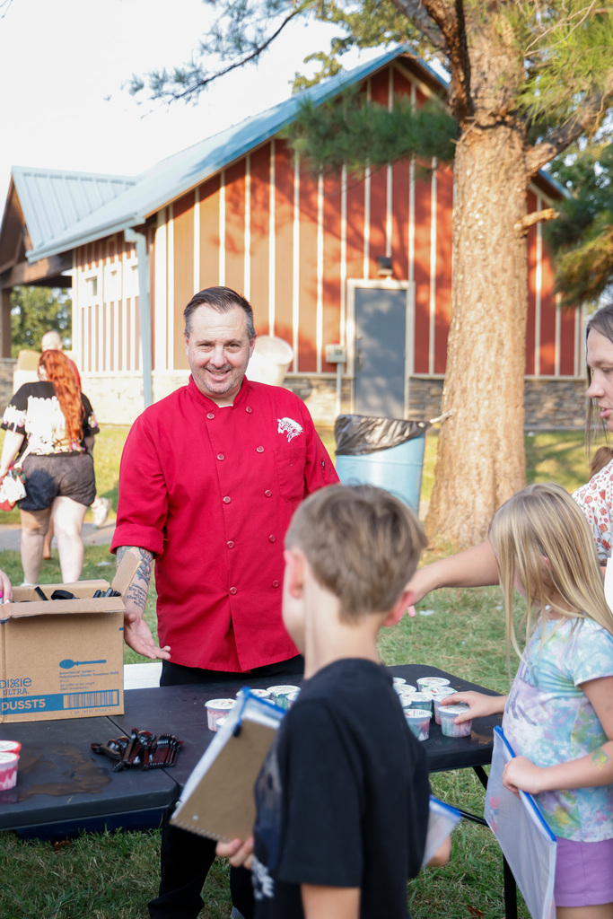 Chef serving ice cream to students 