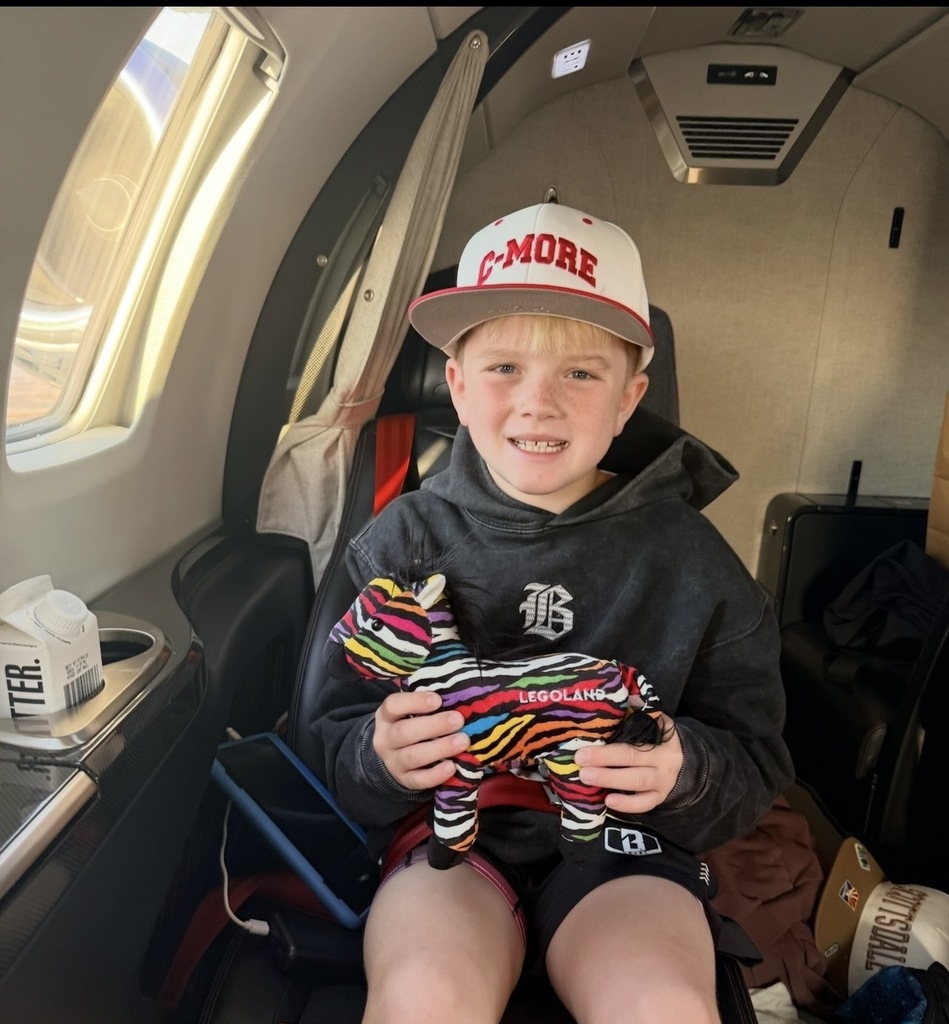 Boy on airplane with stuffed zebra