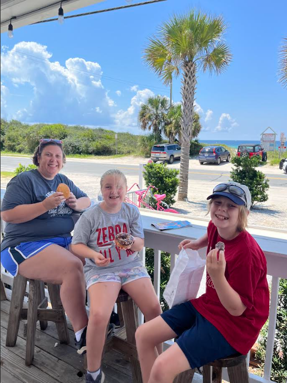 Family eating donuts by the beach