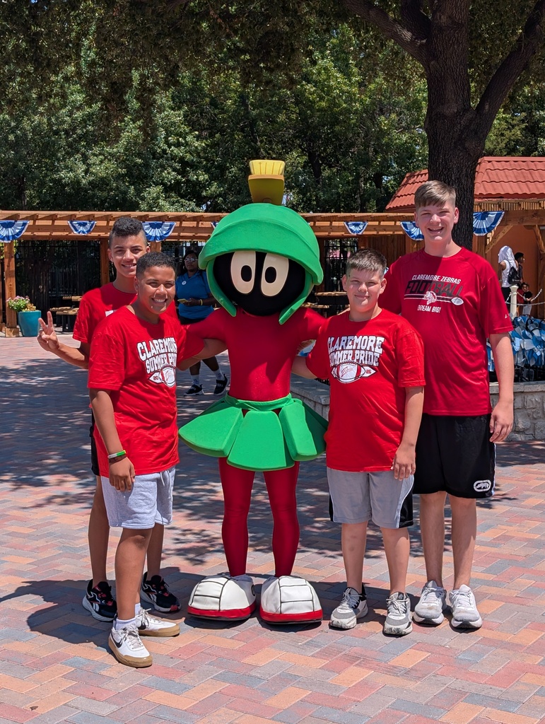 Four students wearing red Claremore Zebra shirts pose with Marvin the Martian at Six Flags Over Texas.