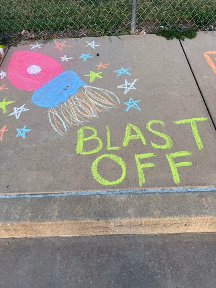 chalk saying blast off with a rocket