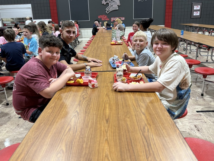 group of boys sitting with officer moree 