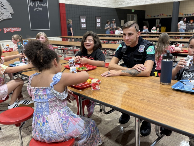 students sitting and talking with officer moree