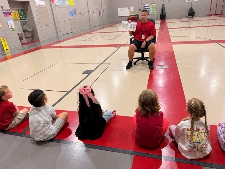 Mr. Hughs reading to elementary students.