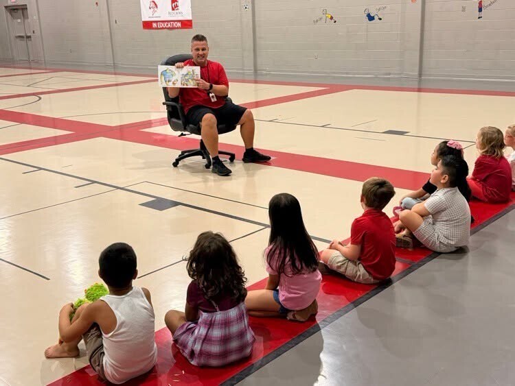 Mr. Hughs reading to elementary students.