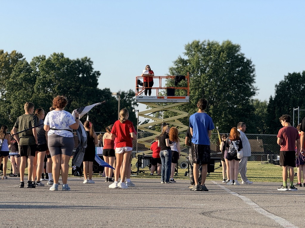 Band director on a lift directing the band in morning rehearsals